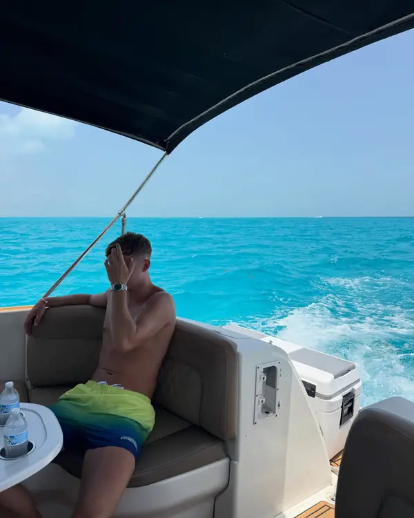 Leon on a boat over turquoise water